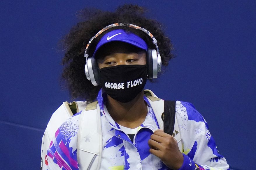 FILE - In this Sept. 8, 2020, file photo, Naomi Osaka, of Japan, wears a protective mask due to the COVID-19 virus outbreak, featuring the name "George Floyd", while arriving on court to face Shelby Rogers, of the United States, during the quarterfinal round of the US Open tennis championships, in New York. Osaka's victory in the U.S. Open helped raised the issue of racial injustice in the United States. Before each of her matches, she wore a mask with the names of seven Black Americans who died as victims of violence.(AP Photo/Frank Franklin II, File)
