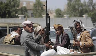 Tribesmen loyal to Houthi rebels hold their weapons as they ride in a vehicle during a gathering against the agreement to establish diplomatic relations between Israel and the United Arab Emirates, in Sanaa, Yemen.  (AP Photo/Hani Mohammed, File)
