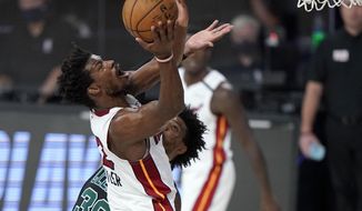 Miami Heat&#39;s Jimmy Butler, front, goes up for a shot over Boston Celtics&#39; Marcus Smart, rear, during the first half of an NBA conference final playoff basketball game, Tuesday, Sept. 15, 2020, in Lake Buena Vista, Fla. (AP Photo/Mark J. Terrill)