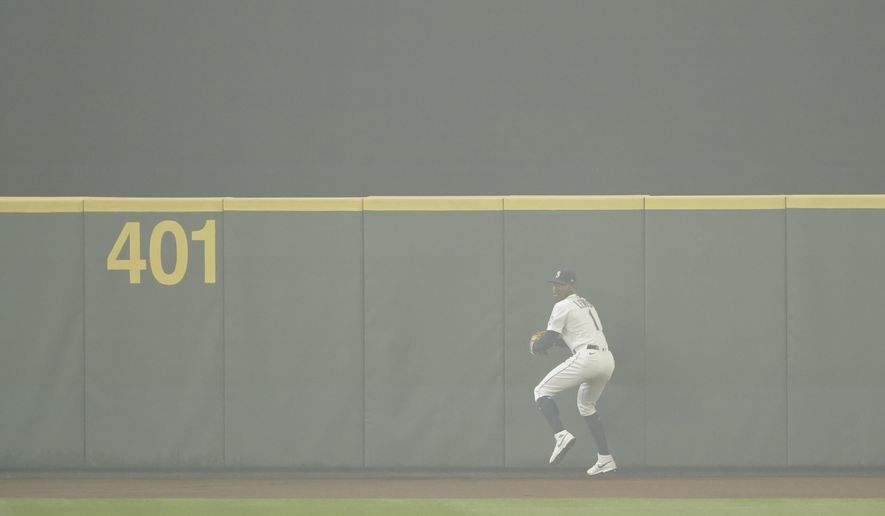 Seattle Mariners center fielder Kyle Lewis prepares to throw the ball back to the infield after making a catch as the air is filled with wildfire smoke during the first baseball game of a doubleheader against the Oakland Athletics, Monday, Sept. 14, 2020, in Seattle. (AP Photo/Ted S. Warren)