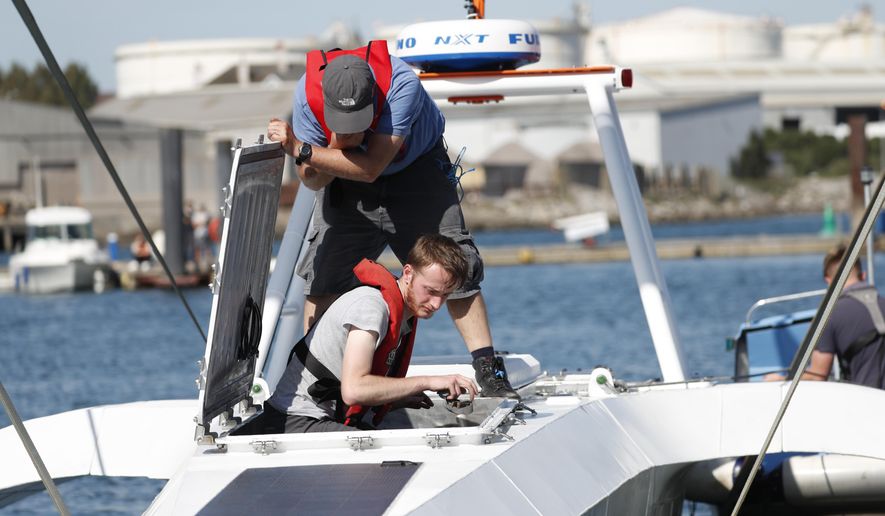 Technicians check the hull and interior of the Mayflower Autonomous Ship at its launch site for it's first outing on water since being built in Turnchapel, Plymouth south west England, Monday, Sept. 14, 2020.  The ship aims to cross the Atlantic from Plymouth, England, to Plymouth, Ma, USA,  in April 2021, to become be the first totally autonomous ship to cross the ocean without any help from the outside. (AP Photo/Alastair Grant)