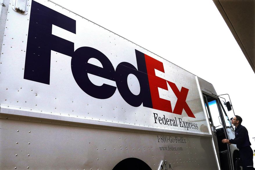 In this Dec. 18, 2014, photo, a Federal Express driver returns to his truck after delivering a package to a business in Springfield, Ill. (AP Photo/Seth Perlman) **FILE**