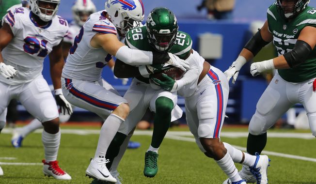 New York Jets running back Le&#x27;Veon Bell (26) is stopped by Buffalo Bills defensive ends Trent Murphy, center left, and Quinton Jefferson, center right, during the first half of an NFL football game in Orchard Park, N.Y., Sunday, Sept. 13, 2020. (AP Photo/Jeffrey T. Barnes)