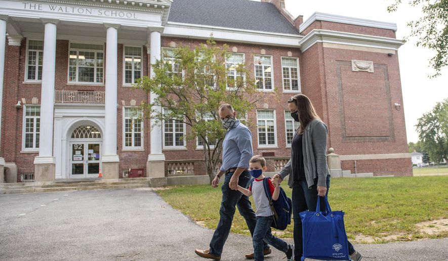 Andrea and Doug Tomer, walk their son Landon to school at the Walton School on Monday morning, Sept. 14, 2020 for the first day of school. (Andree Kehn/Sun Journal via AP)