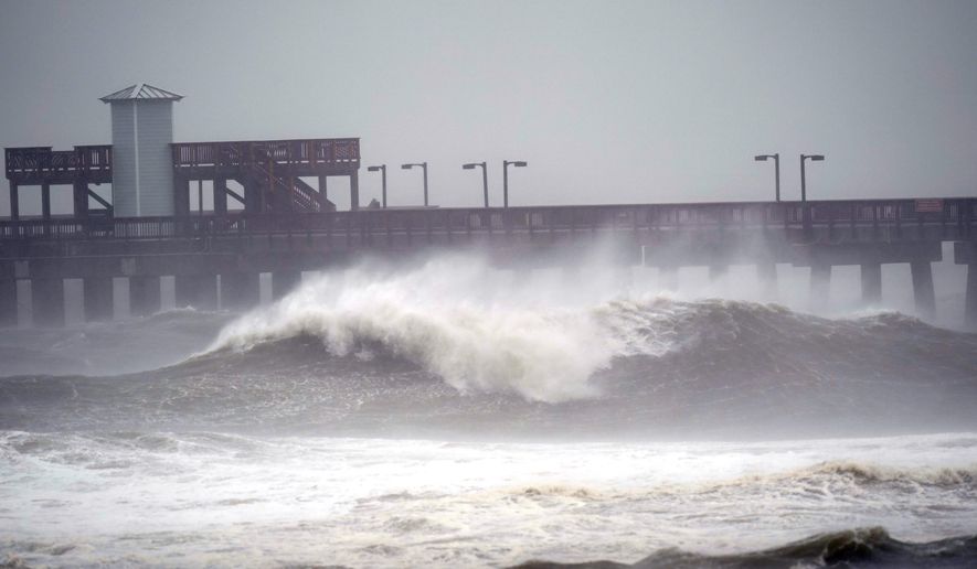 Waves crash near a pier, at Gulf State Park, Tuesday, Sept. 15, 2020, in Gulf Shores, Ala. Hurricane Sally is crawling toward the northern Gulf Coast at just 2 mph, a pace that&#39;s enabling the storm to gather huge amounts of water to eventually dump on land. (AP Photo/Gerald Herbrt)