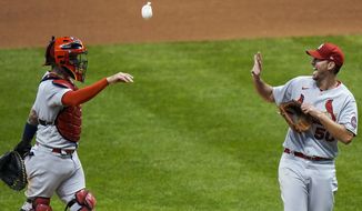 St. Louis Cardinals catcher Yadier Molina throws Adam Wainwright a rosin bag after the first game of a baseball doubleheader against the Milwaukee Brewers Wednesday, Sept. 16, 2020, in Milwaukee. Wainwright pitched a complete game as the Cardinals won 4-2. (AP Photo/Morry Gash)