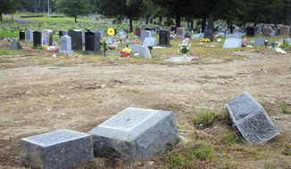 FILE - In this Oct. 2, 2018 file photo, toppled headstones rest on the ground in Park Cemetery in Bridgeport, Conn. The former caretaker of the cemetery is facing a new charge of embezzling more than $60,000 from the cemetery. Dale LaPrade, 66, was charged with first-degree larceny on Sept. 10 after a forensic audit discovered the theft of funds from Park Cemetery in Bridgeport between 2016 and 2018. (Ned Gerard/Hearst Connecticut Media via AP)