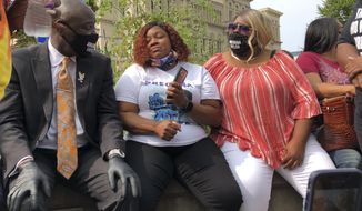 Tamika Palmer, Breonna Taylor&#39;s mother, in white beside Attorney Ben Crump, left, speak in Louisville, Ky., after settlement was announced. The city of Louisville will pay $12 million to the family of Breonna Taylor and reform police practices as part of a lawsuit settlement months after Taylor&#39;s slaying by police thrust the Black woman&#39;s name to the forefront of a national reckoning on race, Mayor Greg Fischer announced Tuesday.(AP Photo/Dylan Lovan)
