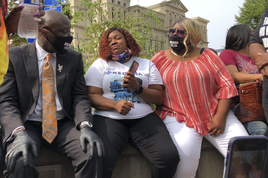 Tamika Palmer, Breonna Taylor&#39;s mother, in white beside Attorney Ben Crump, left, speak in Louisville, Ky., after settlement was announced. The city of Louisville will pay $12 million to the family of Breonna Taylor and reform police practices as part of a lawsuit settlement months after Taylor&#39;s slaying by police thrust the Black woman&#39;s name to the forefront of a national reckoning on race, Mayor Greg Fischer announced Tuesday.(AP Photo/Dylan Lovan)