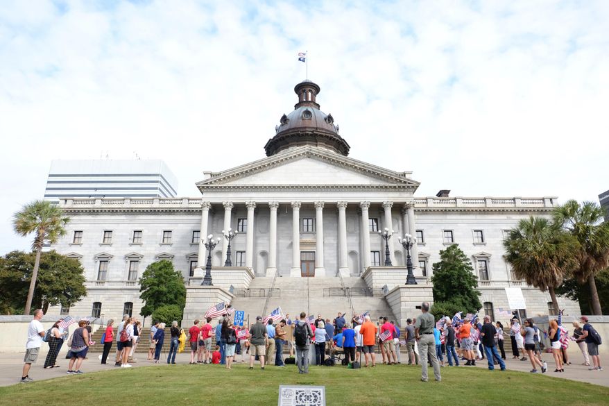 Protesters from conservative organizations, including the Greenville TEA Party and South Carolina Patriots for Liberty, gather without masks outside the South Carolina Statehouse in Columbia, S.C., Tuesday, Sept. 15, 2020. The groups called on Gov. Henry McMaster and other state and local leaders to end gathering and business restrictions and mask mandates issued to limit the spread of COVID-19. (AP Photo/Michelle Liu)