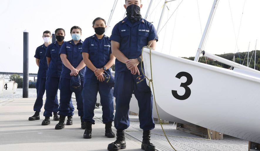 In this Monday Sept. 14, 2020 photo, From back left, Coast Guard Academy Cadets Henry Smith, Branyelle Carillo, Mia Haskovec, Jordan Park, and Tyler Huynh, pose for a photograph at the Seamanship Sailing Center at the United State Coast Guard Academy in New London, Conn. A group of Coast Guard cadets spent part of their summer filling in on a critical national security mission after a case of COVID-19 sidelined crew members on a cutter being sent to patrol the US-Russia border. (AP Photo/Jessica Hill)