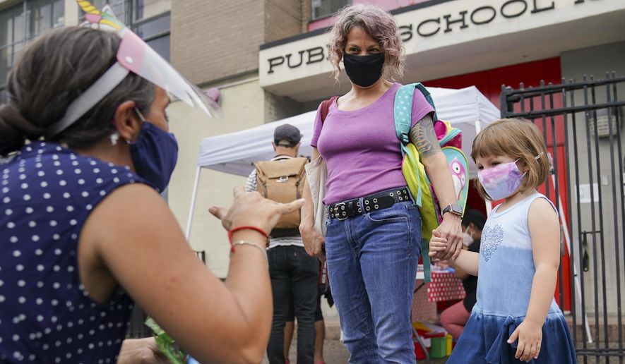 FILE- In this Sept. 2, 2020 file photo, teachers and students participate in an outdoor learning demonstration to display methods schools can use to continue on-site education during the coronavirus pandemic, at P.S. 15 in the Red Hook neighborhood of the Brooklyn borough of New York. New York City's already delayed school year is scheduled to start remotely on Wednesday, Sept. 16, 2020, in a soft opening that will serve as a prologue to the return of students to physical classrooms on the following week. (AP Photo/John Minchillo, File)