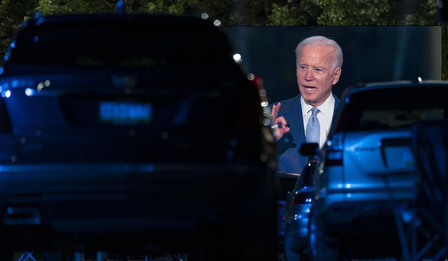 Audience members watch from their cars as Democratic presidential candidate former Vice President Joe Biden, seen on a large monitor, speaks during a CNN town hall moderated by Anderson Cooper in Moosic, Pa., Thursday, Sept. 17, 2020. (AP Photo/Carolyn Kaster)