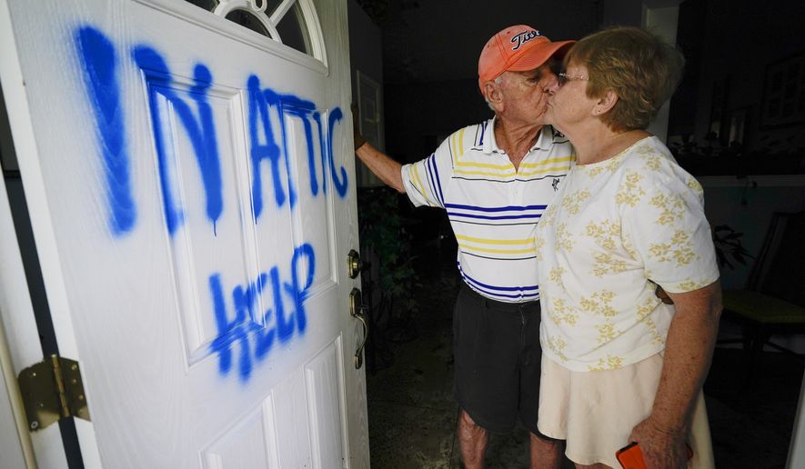 Elaine and Jack Hulgan pose for a portrait after riding out the hurricane in their attic, Thursday, Sept. 17, 2020, in Cantonment, Fla. Rivers swollen by Hurricane Sally's rains threatened more misery for parts of the Florida Panhandle and south Alabama on Thursday, as the storm's remnants continued to dump heavy rains inland that spread the threat of flooding to Georgia and the Carolinas.(AP Photo/Gerald Herbert)