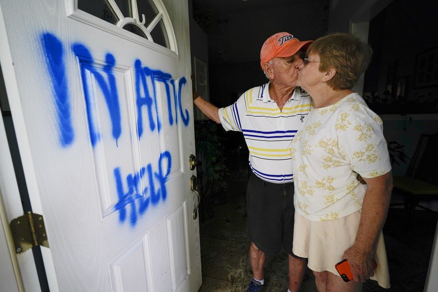 Elaine and Jack Hulgan pose for a portrait after riding out the hurricane in their attic, Thursday, Sept. 17, 2020, in Cantonment, Fla. Rivers swollen by Hurricane Sally's rains threatened more misery for parts of the Florida Panhandle and south Alabama on Thursday, as the storm's remnants continued to dump heavy rains inland that spread the threat of flooding to Georgia and the Carolinas.(AP Photo/Gerald Herbert)