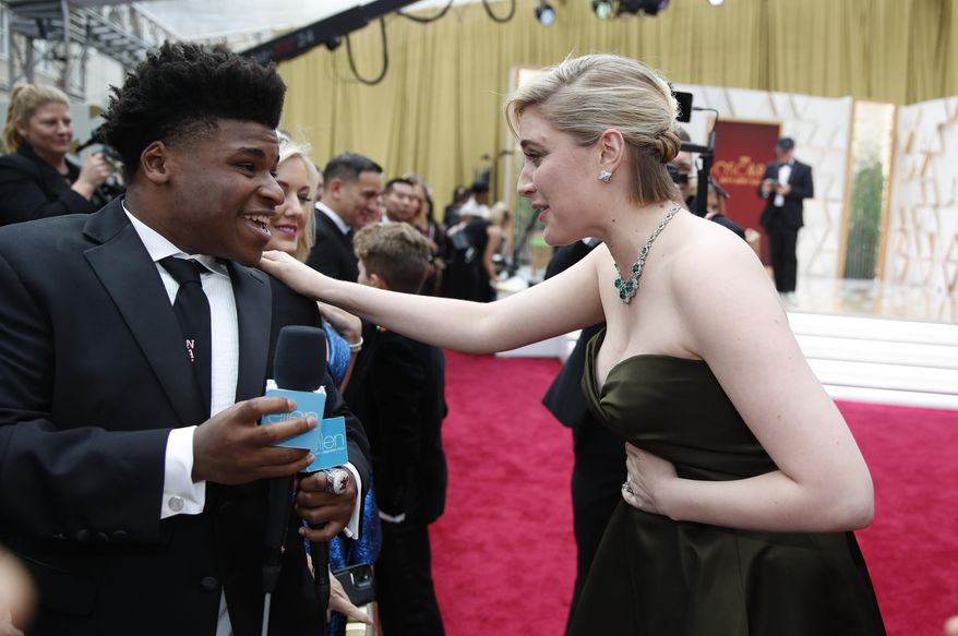FILE - In this Feb. 9, 2020 file photo, Greta Gerwig, right, talks to Jerry Harris on the red carpet at the Oscars at the Dolby Theatre in Los Angeles. Harris, the star of the Netflix documentary series “Cheer,” was arrested Thursday, Sept. 17 on child pornography charges. (AP Photo/John Locher File)