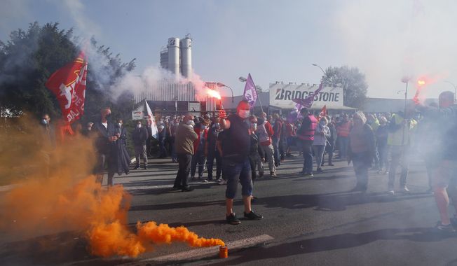 Bridgestone employees fire flares outside the tire factory of Bethune, northern France, Thursday, Sept.17, 2020. Workers protest over the Japan-based company&#x27;s decision to close the plant and lay off all its nearly 900 workers. Bridgestone argues the factory is no longer competitive globally, but unions and French politicians accused the company of using the virus-driven economic crisis as a pretext for the closure and not investing in modernizing the plant instead. (AP Photo/Michel Spingler)