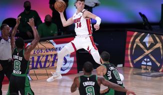Miami Heat guard Tyler Herro (14) leaps to make a pass over Boston Celtics&#39; Kemba Walker (8), Brad Wanamaker (9) and Jayson Tatum (0) during the second half of an NBA conference final playoff basketball game, Thursday, Sept. 17, 2020, in Lake Buena Vista, Fla. (AP Photo/Mark J. Terrill)