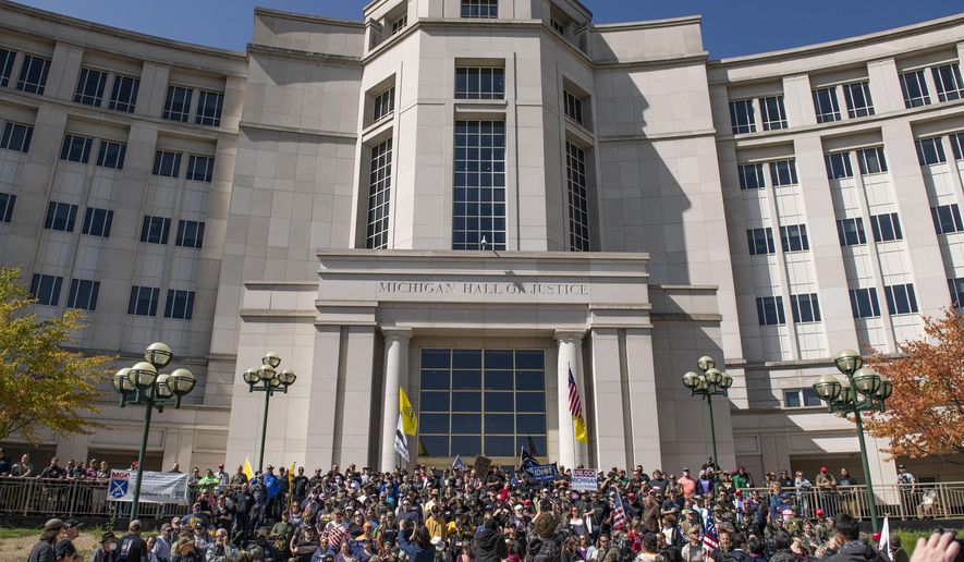 Open carry gun activist stand on the steps of the Michigan Hall of Justice on Thursday Sep. 17, 2020 in Lansing, Mich. (Nicole Hester/Ann Arbor News via AP)