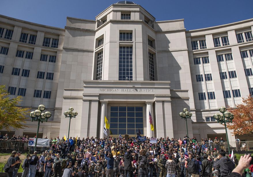 Open carry gun activist stand on the steps of the Michigan Hall of Justice on Thursday Sep. 17, 2020 in Lansing, Mich. (Nicole Hester/Ann Arbor News via AP)