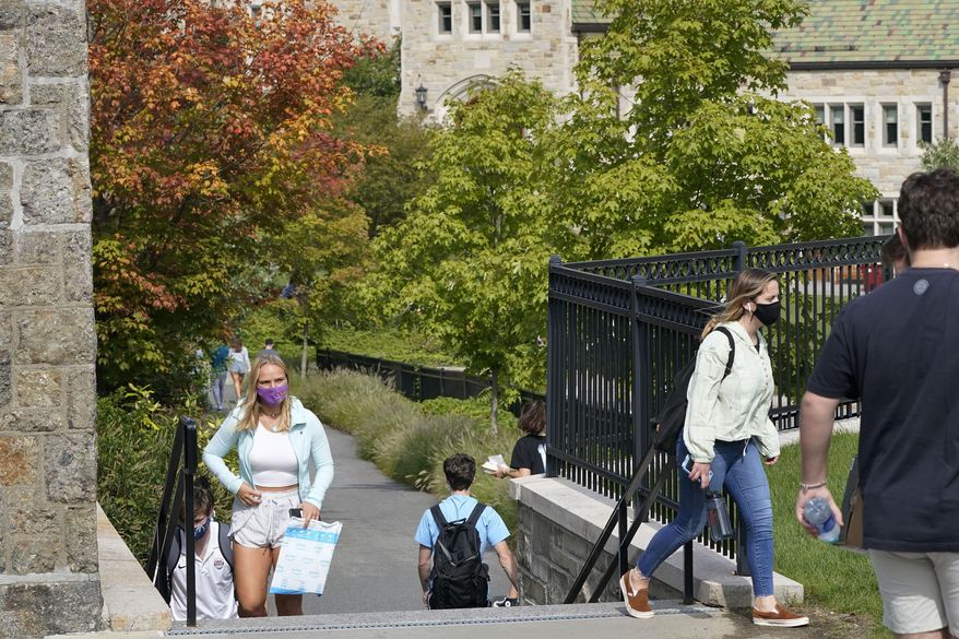 College students wear masks our of concern for the coronavirus on the Boston College campus, Thursday, Sept. 17, 2020, in Boston. (AP Photo/Steven Senne)