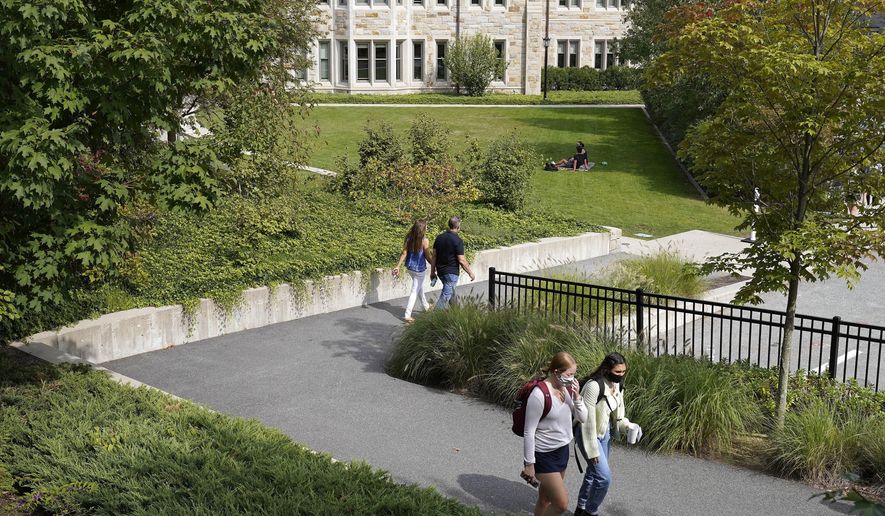 College students wear masks our of concern for the coronavirus on the Boston College campus, Thursday, Sept. 17, 2020, in Boston. (AP Photo/Steven Senne)