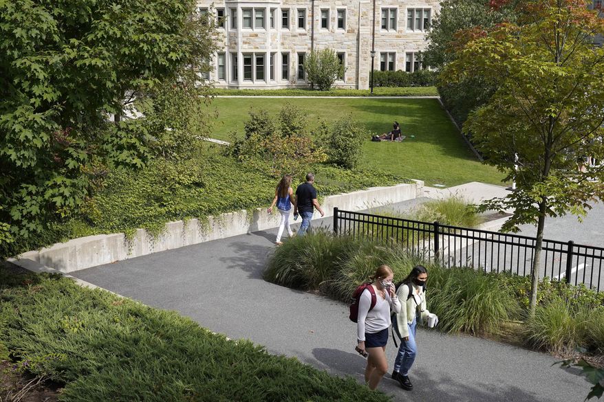 College students wear masks our of concern for the coronavirus on the Boston College campus, Thursday, Sept. 17, 2020, in Boston. (AP Photo/Steven Senne)