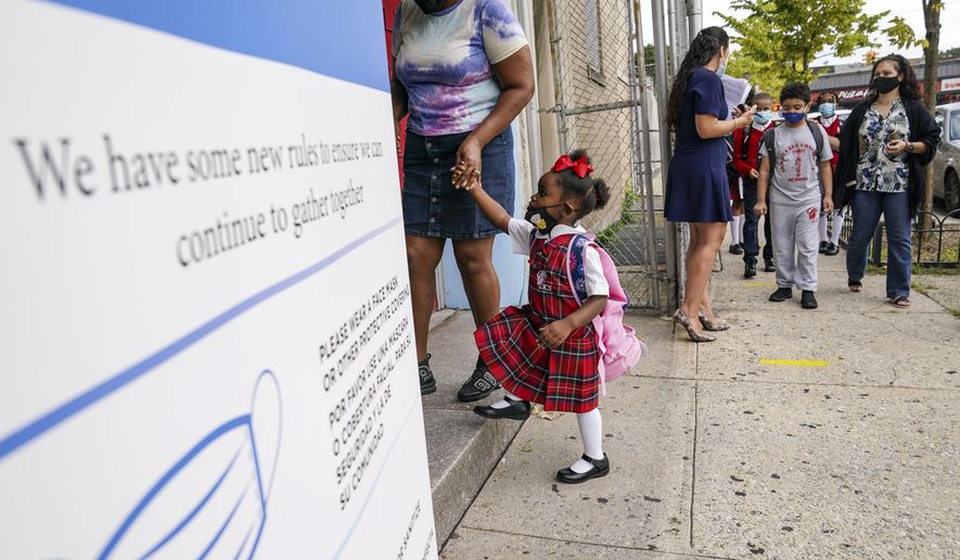 Students wear protective masks as they arrive for classes at the Immaculate Conception School while observing COVID-19 prevention protocols, Wednesday, Sept. 9, 2020, in the Bronx borough of New York. (AP Photo/John Minchillo)