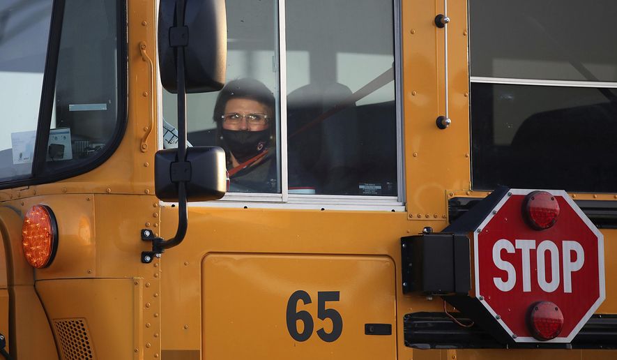 A bus driver travels her route on the first day of in-person instruction at Owasso schools Thursday, Sept. 17, 2020 in Owasso, Okla.   (Mike Simons/Tulsa World via AP)