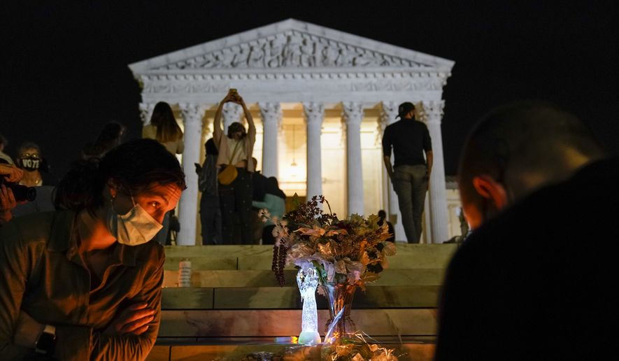 People gather at the Supreme Court Friday, Sept. 18, 2020, in Washington, after the Supreme Court announced that Supreme Court Justice Ruth Bader Ginsburg died of metastatic pancreatic cancer at age 87. (AP Photo/Alex Brandon)