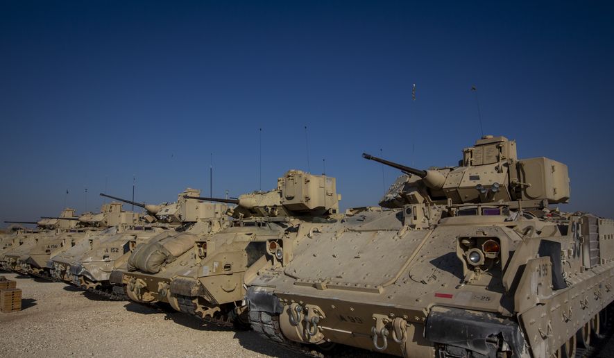 In this Nov. 11, 2019, file photo, Bradley fighting vehicles are parked at a U.S. military base at an undisclosed location in Northeastern Syria, Monday, Nov. 11, 2019. (AP Photo/Darko Bandic) **FILE**