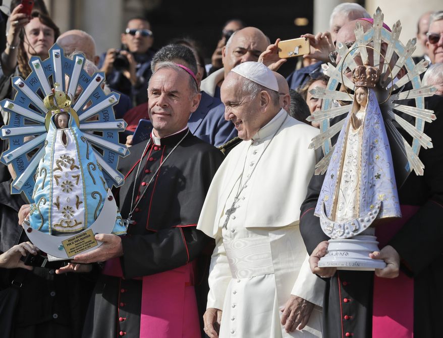 In this Oct. 30, 2019, file photo, Pope Francis poses for photographs with British Bishop Paul Mason, left, as they hold statues of Our Lady of Lujan, the original held at right, and its replica, left, at the end of his weekly general audience in St. Peter&#x27;s Square, at the Vatican. Pope Francis is giving his blessing to a new Vatican think tank that is seeking to prevent the Mafia and organized crime groups from exploiting the image of the Virgin Mary for their own illicit ends. (AP Photo/Andrew Medichini)