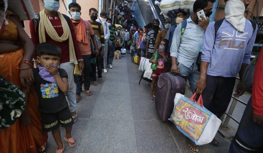 Indian passengers queue up to test for COVID-19 at a facility erected at a railway station to screen people coming from outside the city, in Ahmedabad, India, Friday, Sept. 18, 2020. India&#39;s coronavirus cases jumped by another 96,424 in the past 24 hours, showing little sign of leveling. India is expected to have the highest number of confirmed cases within weeks, surpassing the United States, where more than 6.67 million people have been infected. (AP Photo/Ajit Solanki)