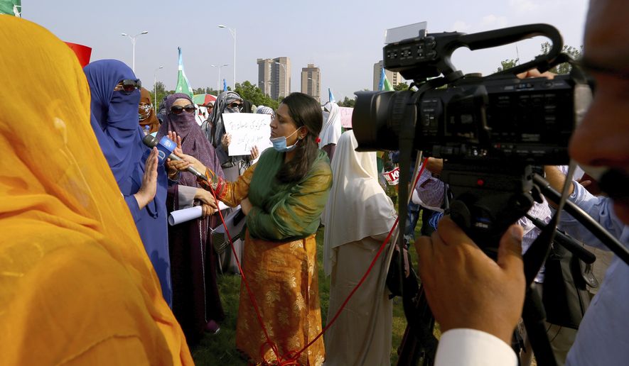 In this Friday, Sept. 11, 2020 photo, Wajiha Khanian, a female journalist from local tv channel Dawn News, interviews during protest, in Islamabad, Pakistan. Social media attacks against Pakistan's women journalists have been vile and vicious, some threatening rape, others even threatening death and the culprits are most often allied to the ruling party, even prompting the Committee to Protect Journalists to issue a statement on Friday condemning the relentless attacks. (AP Photo/Anjum Naveed)