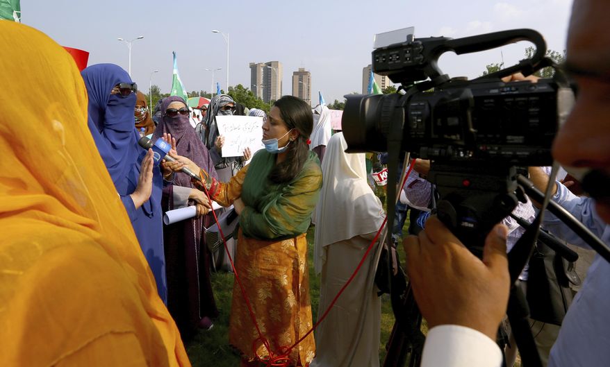 In this Friday, Sept. 11, 2020 photo, Wajiha Khanian, a female journalist from local tv channel Dawn News, interviews during protest, in Islamabad, Pakistan. Social media attacks against Pakistan's women journalists have been vile and vicious, some threatening rape, others even threatening death and the culprits are most often allied to the ruling party, even prompting the Committee to Protect Journalists to issue a statement on Friday condemning the relentless attacks. (AP Photo/Anjum Naveed)