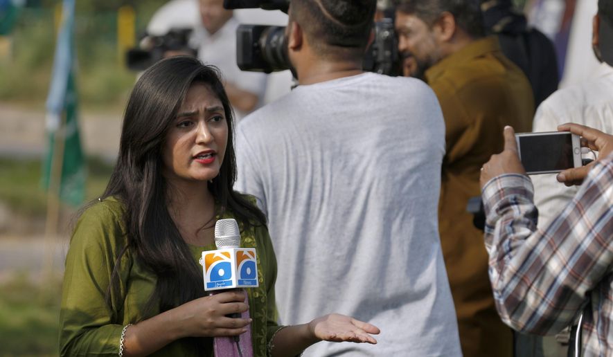 In this Friday, Sept. 11, 2020, file photo, Alena Waqar, a female journalist from local tv channel Geo News, gives live reporting during a rally, in Islamabad, Pakistan. Social media attacks against Pakistan's women journalists have been vile and vicious, some threatening rape, others even threatening death and the culprits are most often allied to the ruling party, even prompting the Committee to Protect Journalists to issue a statement on Friday condemning the relentless attacks. (AP Photo/Anjum Naveed) ** FILE **