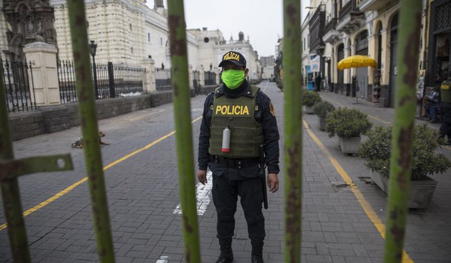 A police officer stands guard one block away from the Constitutional Court building in Lima, Peru, Thursday, Sept. 17, 2020. The court rejected a request by President Martin Vizcarra Thursday to halt impeachment proceedings being pushed by opposition lawmakers who contend he tried to cover up ties with a controversial ally. (AP Photo/Rodrigo Abd)