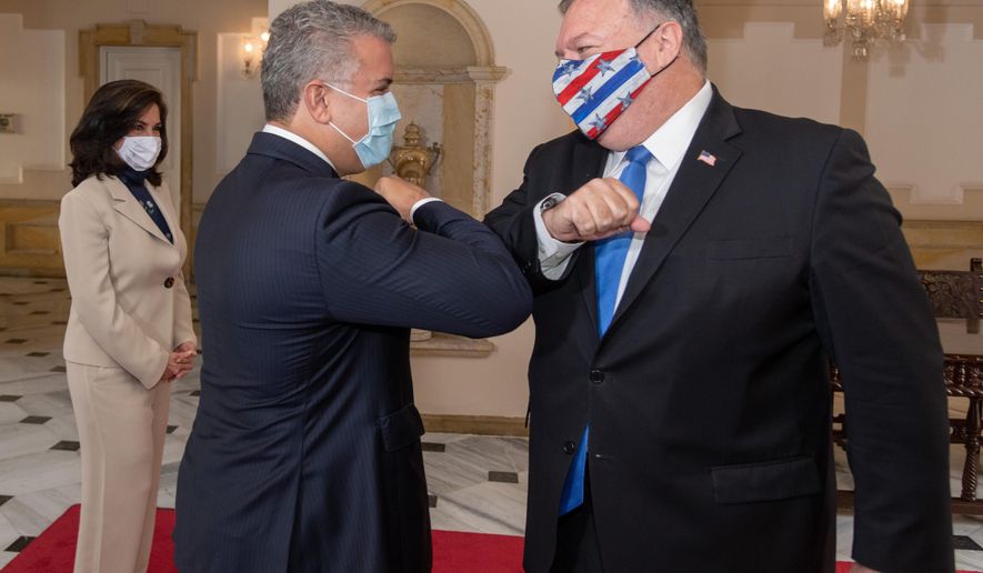 In this handout photo released by Colombia&#39;s Presidential Press Office, Colombian President Ivan Duque and U.S. Secretary of State Mike Pompeo bump elbows before their meeting at the presidential house in Bogota, Colombia, Saturday, Sept. 19, 2020. Pompeo on Saturday wrapped up a tour of four South American countries — three of them neighbors of Venezuela, whose socialist government is under intense U.S. pressure. (Nicolas Galeano/Colombia&#39;s Presidential Press Office via AP)