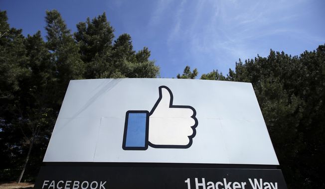FILE - In this April 14, 2020 file photo, the thumbs up Like logo is shown on a sign at Facebook headquarters in Menlo Park, Calif. As President Donald Trump denies that Russia is interfering in the U.S. election and as he tries to block information to Congress, private companies such as Microsoft and Facebook are stepping into the breach. The private sector has become much more forthcoming about election interference since 2016, providing frequent briefings to key members of Congress. (AP Photo/Jeff Chiu, File)