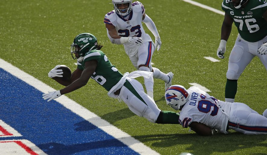 New York Jets running back Josh Adams (36) falls into the endzone for a touchdown while in the grasp of Buffalo Bills defensive tackle Ed Oliver (91) during the second half of an NFL football game in Orchard Park, N.Y., Sunday, Sept. 13, 2020. The Bills won 27-17. (AP Photo/John Munson)