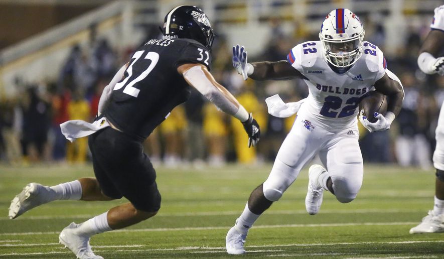 Louisiana Tech running back Israel Tucker (22) wards off a tackle from Southern Mississippi linebacker Hayes Maples (32) during the first half of an NCAA college football game in Hattiesburg, Miss., Saturday, Sept. 19, 2020. (Alyssa Newton/The Sun Herald, via AP)