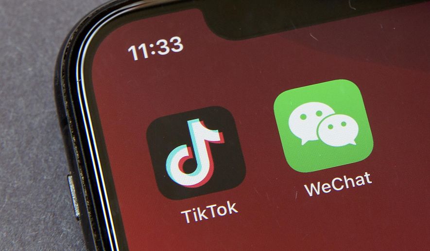 FILE - In this  Friday, Aug. 7, 2020 file photo, Icons for the smartphone apps TikTok and WeChat are seen on a smartphone screen in Beijing.  The U.S. government is cracking down on the Chinese apps TikTok and WeChat, starting by barring them from app stores on Sunday, Sept. 20, 2020. (AP Photo/Mark Schiefelbein, File)