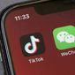 FILE - In this  Friday, Aug. 7, 2020 file photo, Icons for the smartphone apps TikTok and WeChat are seen on a smartphone screen in Beijing.  The U.S. government is cracking down on the Chinese apps TikTok and WeChat, starting by barring them from app stores on Sunday, Sept. 20, 2020. (AP Photo/Mark Schiefelbein, File)
