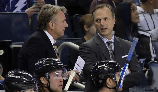 FILE - In this Nov. 21, 2015, file photo, Tampa Bay Lightning head coach Jon Cooper, right, talks to assistant coach Rick Bowness during the first period of an NHL hockey game against the Anaheim Ducks in Tampa, Fla. For the first time in NHL history, a coach is facing a former assistant in the Stanley Cup Final. Dallas Stars interim coach Bowness worked five years as an assistant under Cooper with the Lightning. They parted ways in 2008 and are now facing off in a series of old school vs. new school coaches. (AP Photo/Chris O&#x27;Meara, File)