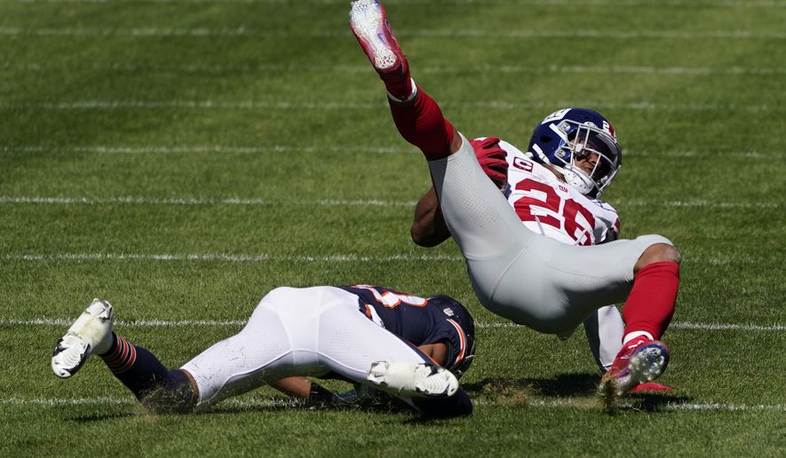 New York Giants running back Saquon Barkley (26) is brought down by Chicago Bears cornerback Kyle Fuller (23) during the first half of an NFL football game in Chicago, Sunday, Sept. 20, 2020. (AP Photo/Charles Rex Arbogast)