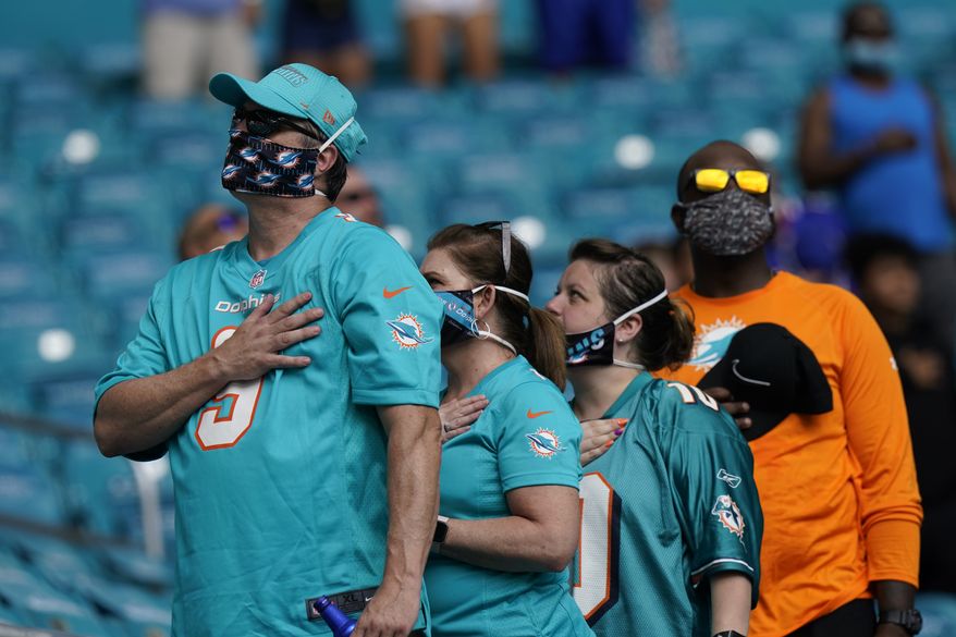 Fans stand for the National Anthem, during the first half of an NFL football game between the Miami Dolphins and the Buffalo Bills, Sunday, Sept. 20, 2020, in Miami Gardens, Fla. (AP Photo/Lynne Sladky)
