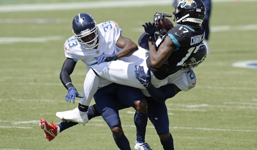 Jacksonville Jaguars wide receiver D.J. Chark (17) makes a catch as he is defended by Tennessee Titans cornerback Johnathan Joseph (33) and cornerback Malcolm Butler (21) in the first half of an NFL football game Sunday, Sept. 20, 2020, in Nashville, Tenn. (AP Photo/Mark Zaleski)