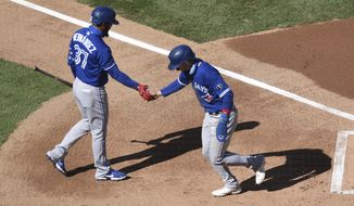 Toronto Blue Jays&#39; Cavan Biggio, right, scores on a balk and is greeted by Teoscar Hernandez during the first inning of a baseball game against the Philadelphia Phillies, Sunday, Sept. 20, 2020, in Philadelphia. (AP Photo/Michael Perez)