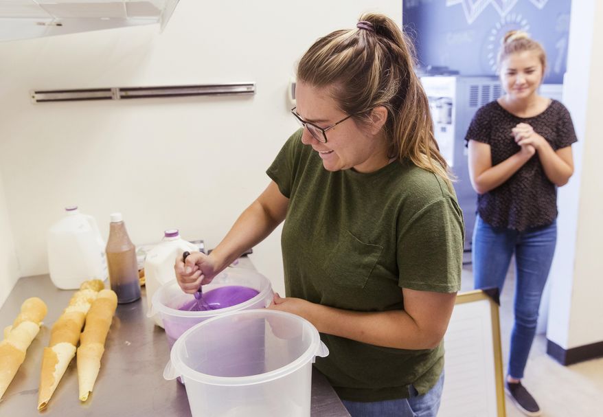 Emily Lewis prepares a batch of ice cream to test out a new batch of homemade waffle cones at The Salted Lemon Market & Creamery Tuesday, Sept. 8, 2020, in Springfield, Ill. Originally, they wanted to purchase cream from Kilgus Farmstead to use in their own soft serve recipe. Now instead, they’ll purchase the basic soft serve mix from the third-generation Fairbury dairy farm. (Ted Schurter/The State Journal-Register via AP)