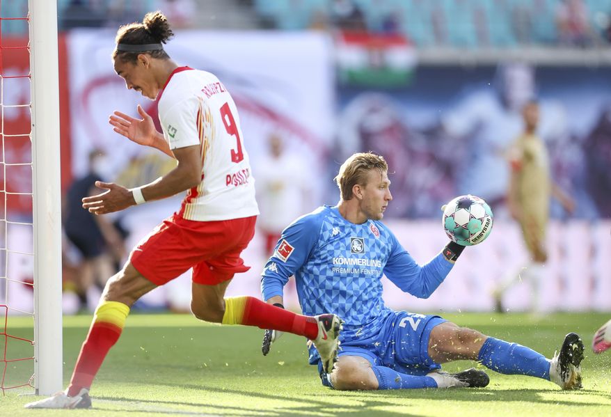 Leipzig's Yussuf Poulsen, left, fails to score against Mainz goalkeeper Robin Zentner during a German Bundesliga soccer match between RB Leipzig and FSV Mainz 05 in Leipzig, Germany, Sunday, Sept. 20, 2020. (Jan Woitas/dpa via AP)
